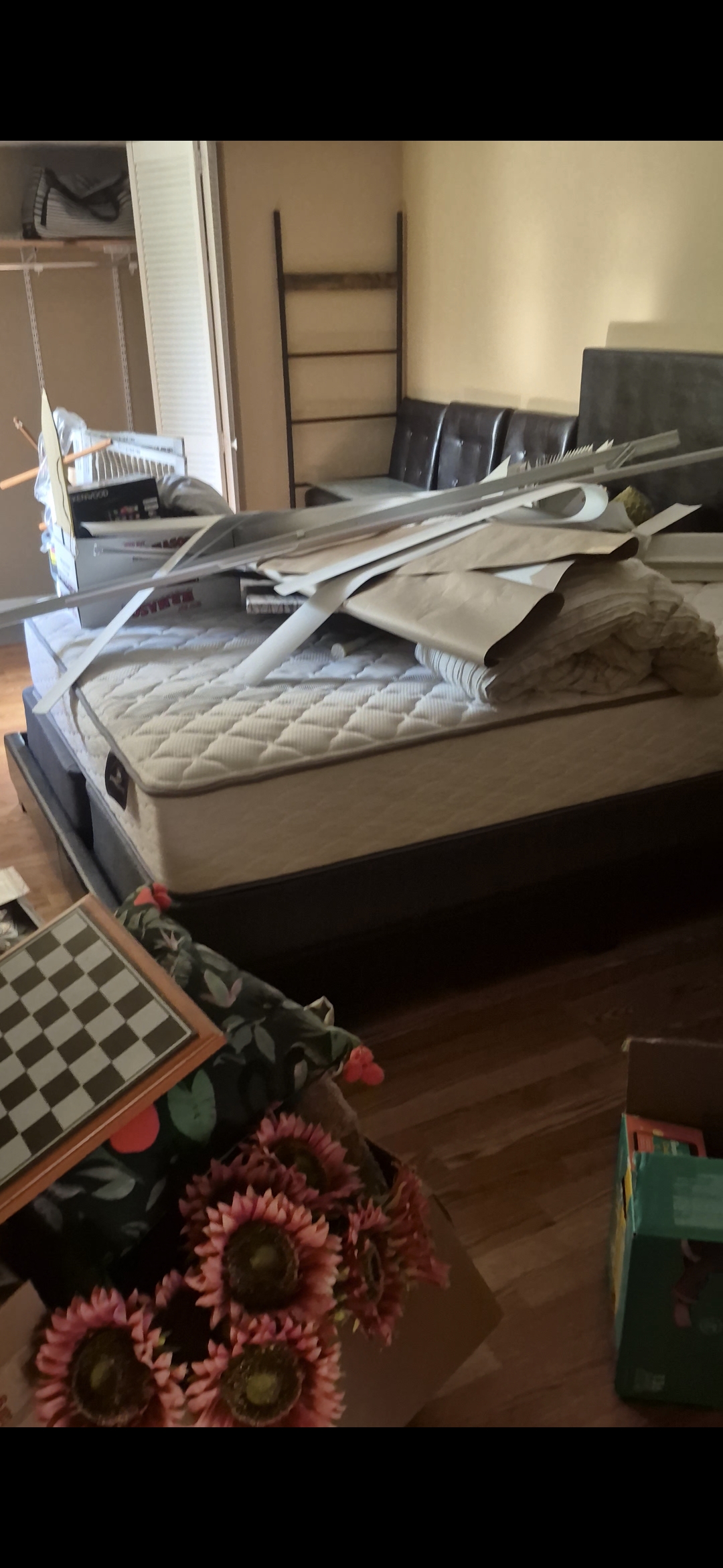 Bedroom in Allentown, PA with a mattress piled high with furniture and household items before removal