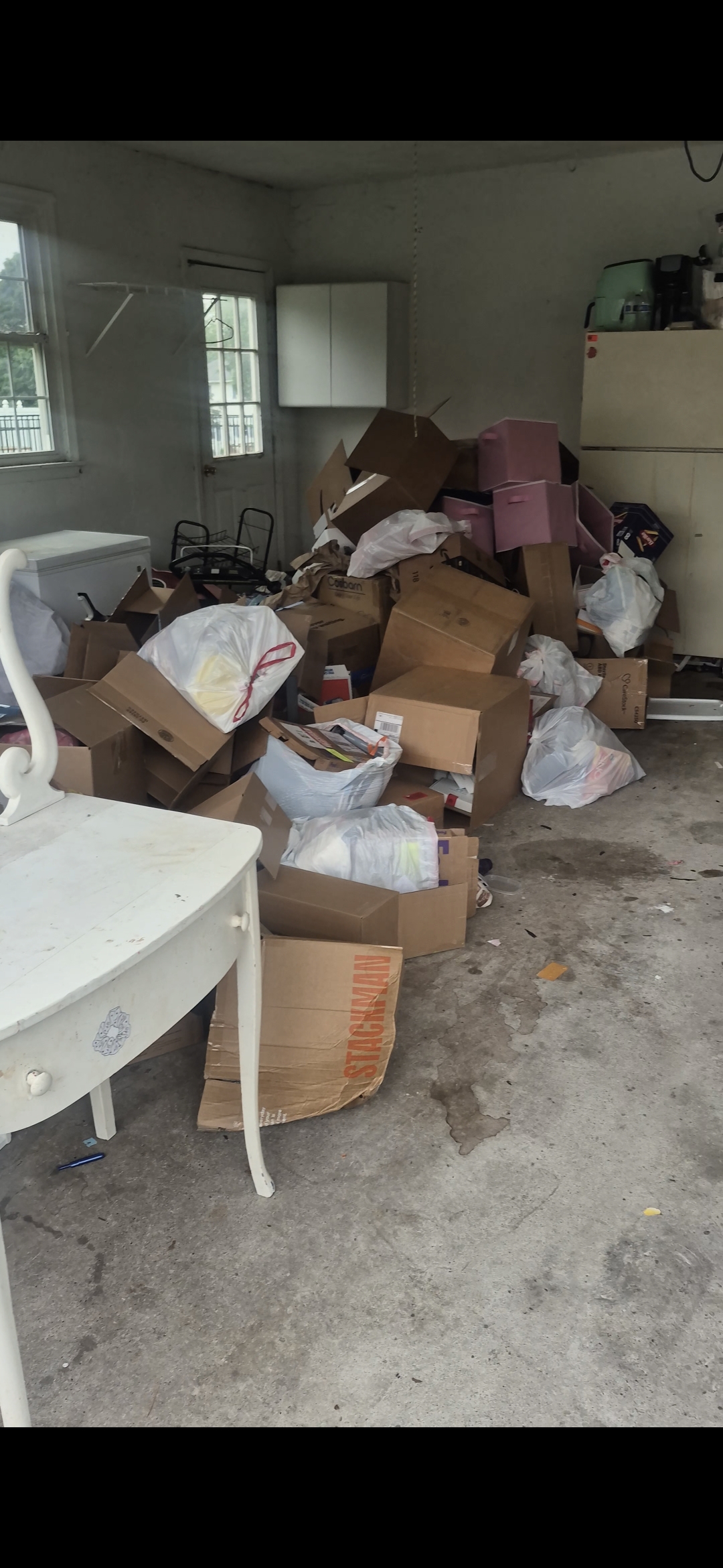 Garage in Bethlehem, PA overflowing with cardboard boxes and trash bags before cleanout