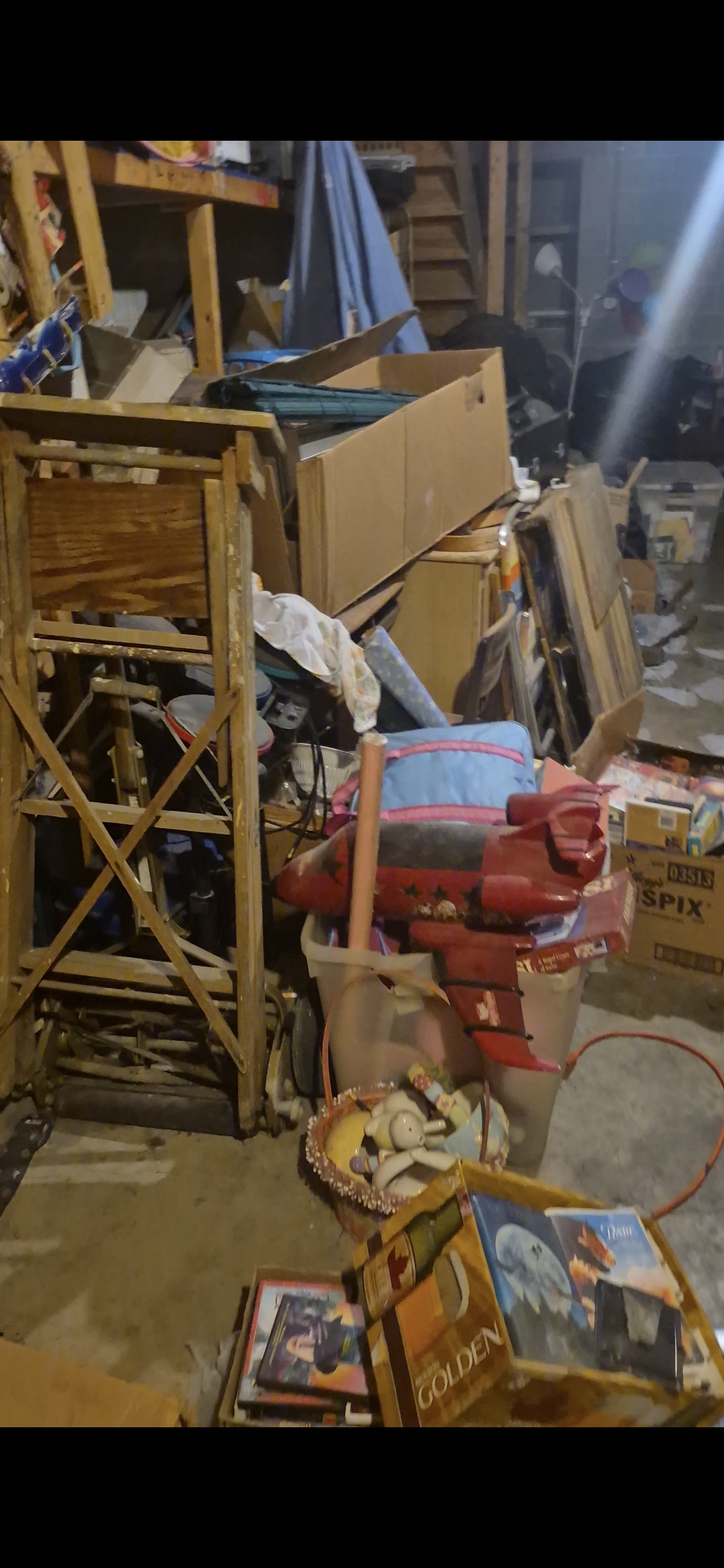Cluttered basement packed with boxes and old shelving before a full property cleanout